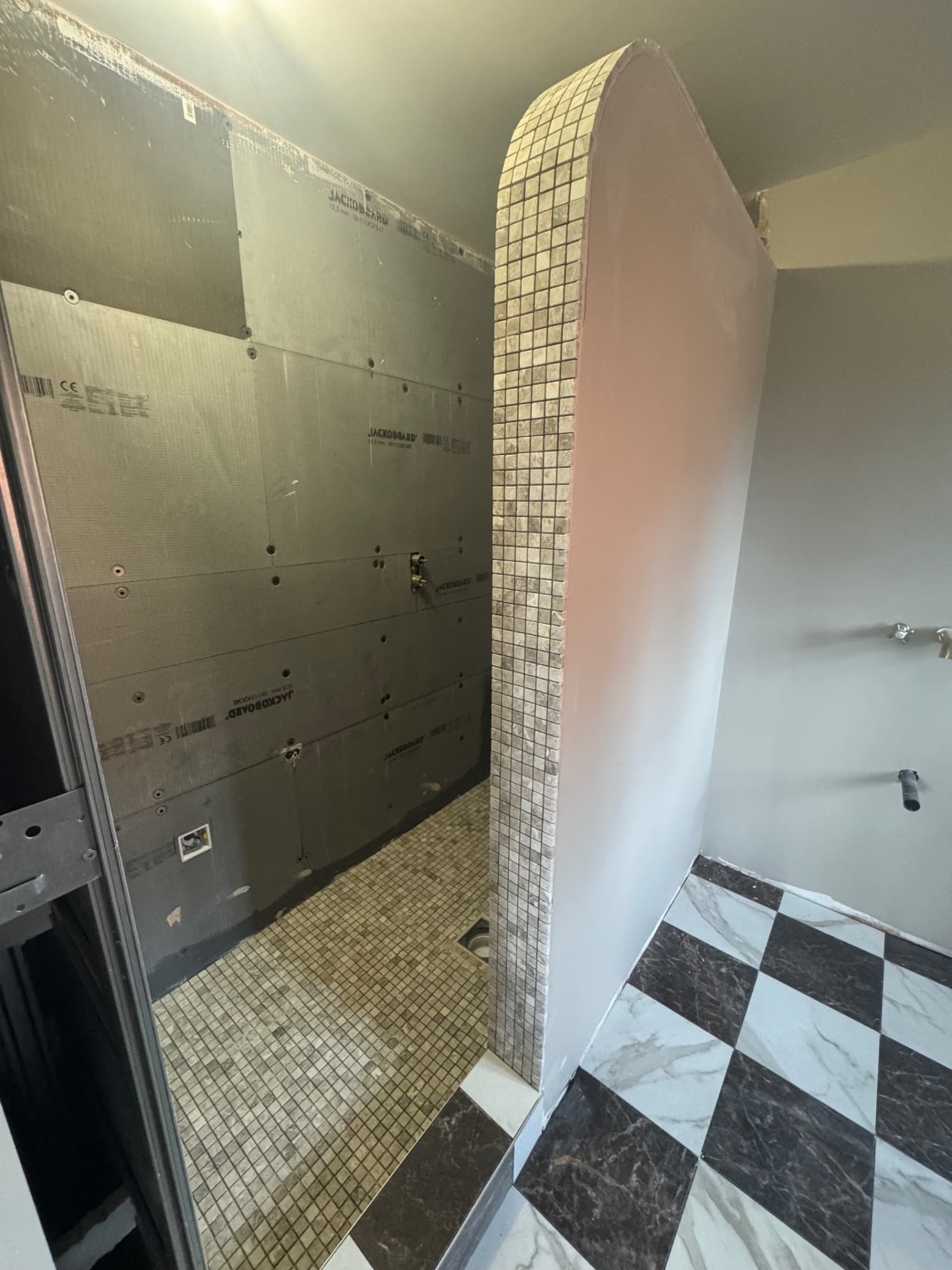 We're in the middle of this bathroom refurb, with the shower enclosure tiled and ready for grouting, and the floor laid out in a classic black and white chequerboard pattern. The walls are prepped and we'll be finishing the remaining surfaces over the next few days.