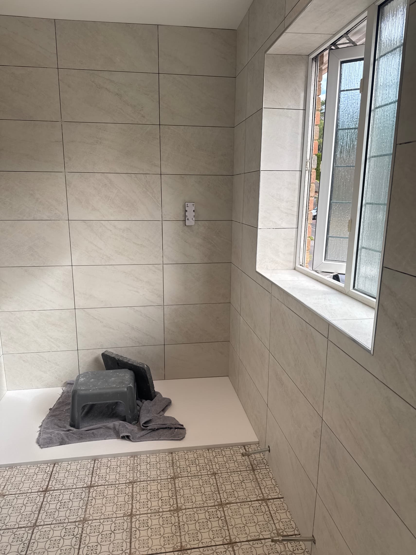We've finished laying all the tiles in this bathroom and we're ready to get the grouting done this morning.